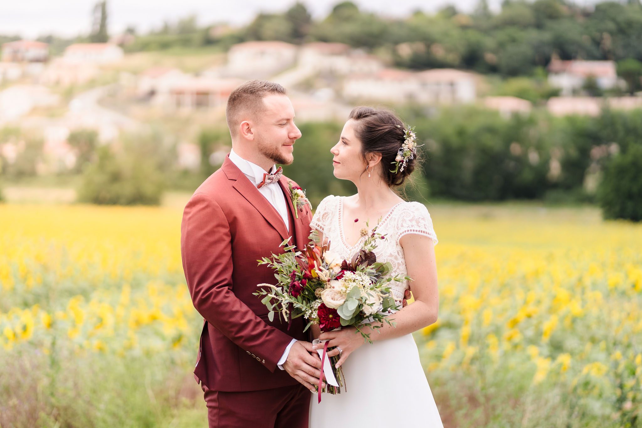 Gaëtan et Océane dans un champ de tournesols, capturé par Michael Jamet, photographe de mariage en Charente